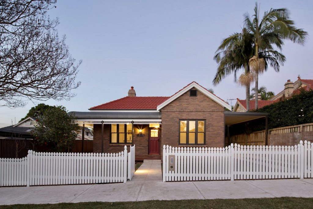 Australian brick home with a white picket fence